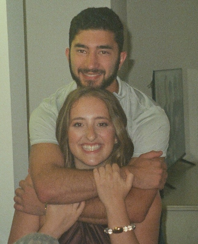 Aaron hugging Shelby from behind, both smiling